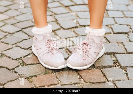 Frau mit neuen bequemen Turnschuhen und weichen pinkfarbenen Rüschen, Nahaufnahme Stockfoto