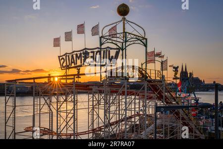 KÖLN, DEUTSCHLAND - 19. APRIL 2023: Skyline der Stadt mit Dom mit Jahrmarkt im Vordergrund bei Sonnenuntergang am 19. April 2023 in Köln Stockfoto