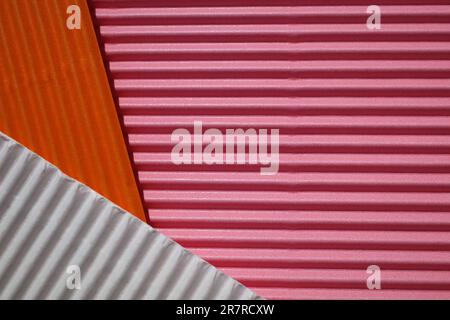 Horizontal und diagonal gerippter Karton mit den Farben Pink, Weiß, Orange. Als Hintergrund gemeint Stockfoto