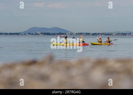 Eine Gruppe von Kanufahrern, die entlang der Küste von Alcanada, Alcudia, Mallorca, Balearen, Spanien segeln Stockfoto