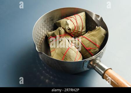 Er hat Zongzi im Topf. Stockfoto