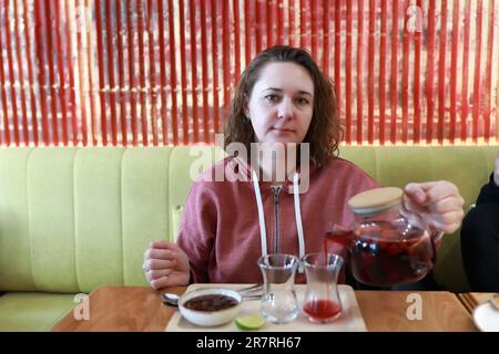 Frau, die im Restaurant Obsttee in armuduistische Gläser gießt Stockfoto