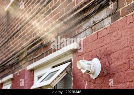 Eine Kesselentlüftung, die Dampf neben einem offenen Fenster ausströmt. Stockfoto