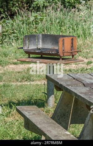 BBQ / Grill und Bank table im öffentlichen Stadtpark bei Lostwithiel, Cornwall. Stockfoto