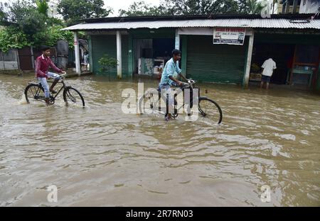 Guwahati, Guwahati, Indien. 17. Juni 2023. Radfahrer waten an einem regnerischen Tag am Samstag, den 17. Juni 2023 in Guwahati Assam India durch die überflutete Straße. (Kreditbild: © Dasarath Deka/ZUMA Press Wire) NUR REDAKTIONELLE VERWENDUNG! Nicht für den kommerziellen GEBRAUCH! Stockfoto