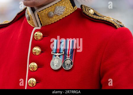 The Mall, Westminster, London, Großbritannien. 17. Juni 2023. Die Royal Family und die Massen und Truppen sind nach der Trooping of the Colour Zeremonie von der Horse Guards Parade zurück in die Mall gereist, in Richtung Buckingham Palace. Es ist das erste unter der Herrschaft von König Karl III Medaillen eines Offiziers der Grenadiergarde. Queen Elizabeth II. Und King Karl III. Krönungsmedaille Stockfoto
