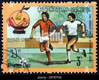 LAOS - UM 1982: Eine in Laos gedruckte Marke zeigt Fußballspieler in Aktion, 1982 WM-Fußballmeisterschaften, Spanien, um 1982 Stockfoto