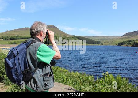 Männlicher Vogelbeobachter im Dove Stone RSPB Nature Reserve Stockfoto