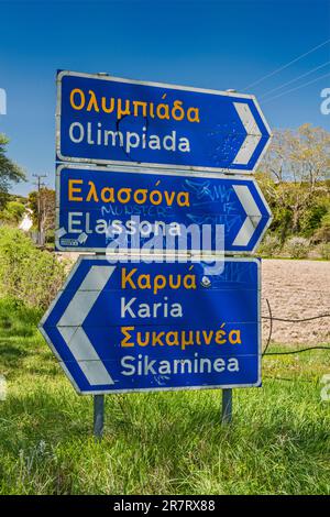 Wegweiser, in griechischem Alphabet und romanisiert (transliteriert), Olymp Gegend, nahe dem Dorf Olimpiada (Olibiada), Thessalien Region, Griechenland Stockfoto