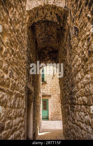 Eine gewölbte Gasse in einer ruhigen Seitenstraße in der historischen Küstenstadt Split in Kroatien Stockfoto