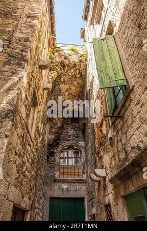 Historische Wohngebäude in der Altstadt von Split in Kroatien. Ein Bogen aus einem früheren Gebäude wurde von anderen Gebäuden umgebaut Stockfoto