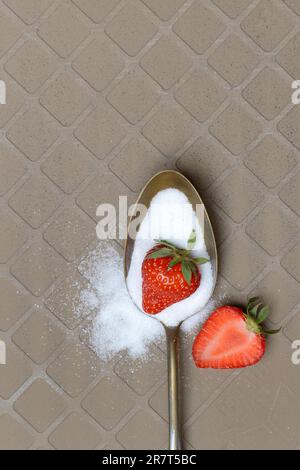 Löffel mit Zucker und Erdbeeren Stockfoto