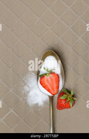Löffel mit Zucker und Erdbeeren Stockfoto