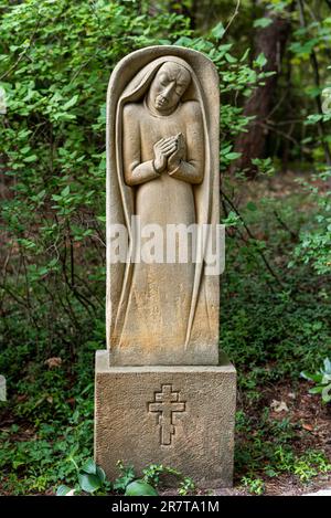 Statue und Grabstein mit Gebetsmädchen und dreiarmigen Kreuzen der Russisch-orthodoxen Kirche im Südwestfriedhof Stahnsdorf, einem berühmten Stockfoto