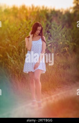 Junge, schöne Frau in weißem Kleid im Maisfeld Stockfoto