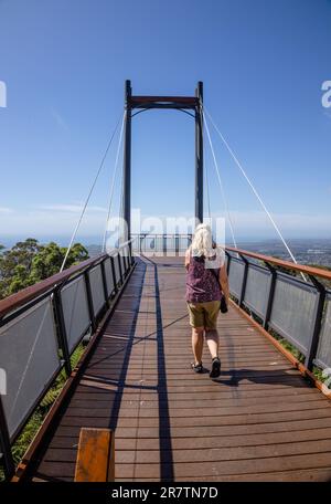 Eine blonde Frau, die am Forest Sky Pier am Sealy Lookout mit Blick auf Coffs Harbour in Australien spaziert. Stockfoto