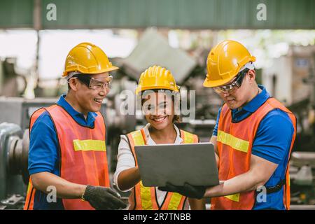 Frau einer Ingenieurarbeiterin mit männlichem Team, die zusammen arbeitet Auditor in der Fabrik, der sich einen Laptop anschaut glückliches Lächeln. Stockfoto