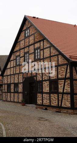 Ein elegantes zweistöckiges Stuckhaus steht im Wohngebiet einer Stadt, mit Fenstern und Balkon mit Blick auf die Straße darunter Stockfoto