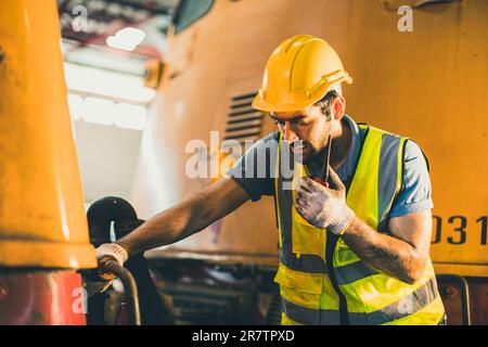 Männlicher Arbeiter hispanic latin Vorarbeiter Funksteuerung arbeitet in Lokomotivwerkstätten Stockfoto