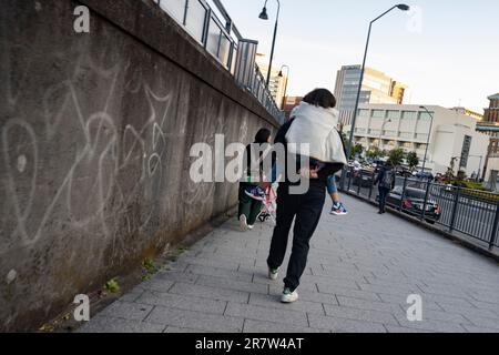 Yokohama, Präfektur Kanagawa, Japan. 23. Februar 2023. Ein Vater, der seine Tochter im Huckepack mitnimmt. Minato Mirai ist ein lebhaftes Hafenviertel in Yokohama, Japan. Es bietet berühmte Wahrzeichen wie den Yokohama Landmark Tower und Cosmo Clock 21, zusammen mit Einkaufszentren, Unterhaltungsstätten und wunderschönen Parks. (Kreditbild: © Taidgh Barron/ZUMA Press Wire) NUR REDAKTIONELLE VERWENDUNG! Nicht für den kommerziellen GEBRAUCH! Stockfoto