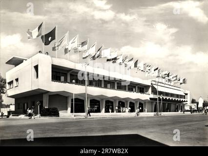 1955 , august , LIDO di VENEZIA , ITALIEN : der gefeierte PALAZZO DEL CINEMA während der Mostra internazionale d'arte cinematografica di Venezia ( Esposizione Internazionale d'Arte Cinematografica - Biennale di Venezia ). Eröffnet am 10. august 1937 für die V Edition des Filmfestivals , entworfen im RATIONALISTISCHEN Stil vom Architekten LUIGI QUAGLIATA ( 1899 - 1991 ). Unbekannter Fotograf .- FESTIVAL DEL CINEMA - CINEMATOGRAFICO - ITALIA - ARCHITETTURA RAZIONALISTA - RATIONALISTISCHE ARCHITEKTUR - VENEDIG - Flagge - bandiera - Nationalflaggen - bandiere nazionali - TURISMO - TOURISMUS - Turisti - Tourist - Stockfoto