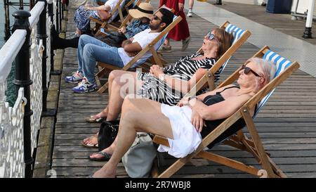 Zwei Frauen schlafen in Liegestühlen am Palace Pier in Brighton Stockfoto