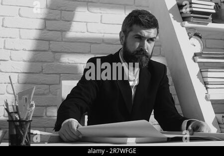 Porträt eines seriösen Lehrers im Schulunterricht. Tutor, Professor, Mentor am Schreibtisch. Lernen, lernen, Trainingskonzept Stockfoto