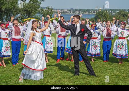 Bei der Stadtfeier spielte eine junge Folkloregruppe eine spontane Hochzeitsszene im ukrainischen Stil. Dnipro, Ukraine - 13. September 2014 Stockfoto