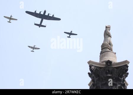 Ein Lancaster-Bomber, flankiert von Spitfire- und Hurricane-Flugzeugen, fliegt über die Nelsons-Säule auf dem Trafalgar Square, der offizielle vorbeifliegt, um den Trooping der Farbe ( Farbe ) offiziellen Geburtstag von König Charles dem dritten im Jahr 2023 zu feiern. Stockfoto