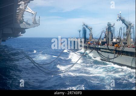 230613-N-OE145-1037 SEELEUTE DER PHILIPPINEN SEE (13. Juni 2023) an Bord der USA USS Ronald Reagan (CVN 76), der einzige in der Zukunft eingesetzte Flugzeugträger der Navy, liefert während eines Tankens auf See mit Flottenauffüllöler USNS Rappahannock (T-AO 204) in der Philippinischen See Lieferpaletten aus der Hangarbucht zurück. Befehlshaber der Task Force 73 (CTF-73) in Abstimmung mit dem militärischen Sealift-Kommando Far East (MSC FE) betankt und liefert entsandte Marinekräfte zusammen mit regionalen Verbündeten und Partnern im Indo-Pazifik nach. Ronald Reagan, das Flaggschiff der Carrier Strike Group 5, bietet eine kampfbereite Truppe, die sich schützt Stockfoto