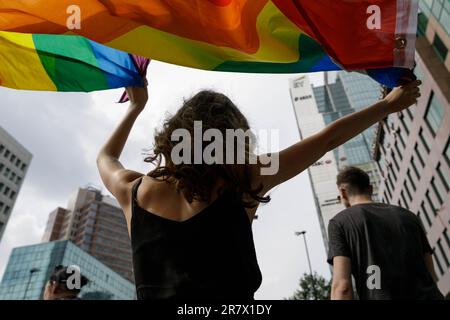 Warschau, Polen. 17. Juni 2023. Eine Frau, die an der Warschauer Gleichstellungsparade teilnimmt, hält die Regenbogenflagge über ihrem Kopf. Die diesjährige Equality Parade widmete sich den Rechten transgender Menschen und wurde unter dem Slogan „We predict Equality and Beauty! Die Equality Parade führte zum 17. Mal durch die Straßen von Warschau. Es ist die größte Manifestation von LGBTQ-Gemeinden in Polen. Kredit: SOPA Images Limited/Alamy Live News Stockfoto