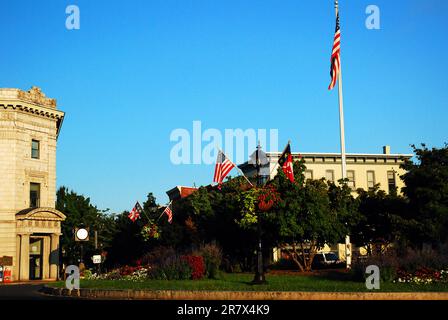 Am Lincoln Square, einem Park im Herzen von Gettysburg, Pennsylvania, steht eine amerikanische Flagge in einem Garten Stockfoto