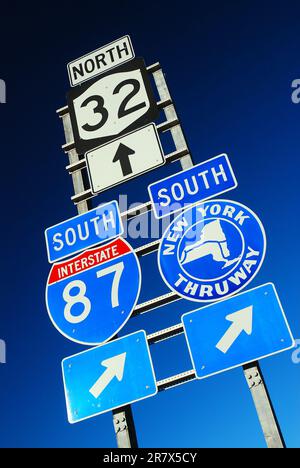 Mehrere Autobahnschilder in Update New York weisen auf die Interstate 85, den New York Thruway und eine State Road hin Stockfoto
