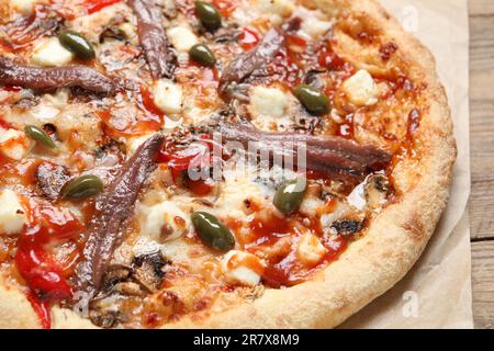 Leckere Pizza mit Sardellen und Oliven auf einem Holztisch, Nahaufnahme Stockfoto