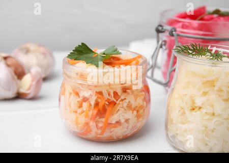 Köstliches Sauerkraut, nach verschiedenen Rezepten auf weißem Tisch zubereitet, Nahaufnahme Stockfoto