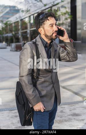 Porträt eines Geschäftsmanns, der vor seinem Büro telefoniert Stockfoto