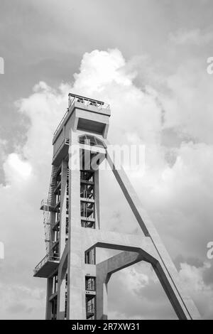 Der Turm des ehemaligen Minenschachts gegen den blauen Himmel. Derzeit ein Aussichtsturm. Ein Denkmal der Technologie. Schwarzweißfoto. Wellenvorsatz Stockfoto