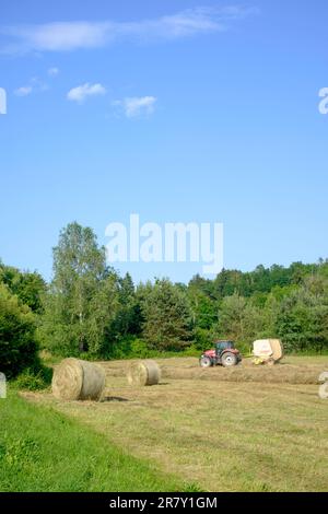 Ballenpressen von zusammengedrehtem Gras im ungarischen Landkreis zala Stockfoto