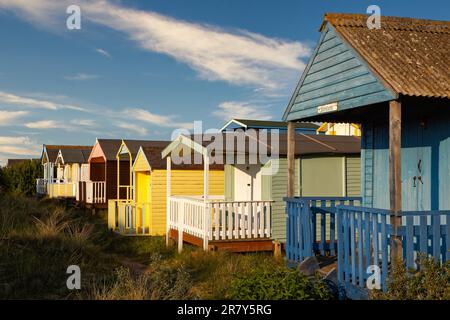 Umkleidekabinen am Strand gebadet in der warmen Abendsonne Stockfoto