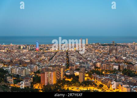 Blick von oben und Nachtfotografie von einem beleuchteten Barcelona. Das Panorama zeigt die berühmte Sagrada Familia, den beleuchteten Torre Agbar und die Stockfoto