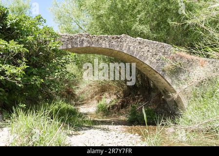 Alte Steinbogenbrücke an einer alten Straße in den südlichen Ausläufern der IDA Range in der Nähe des Bergdorfes Laloumas im südlichen Zentrum von Kreta, Griechenland Stockfoto