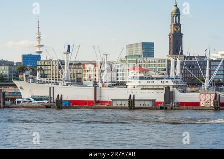 Skyline der Stadt von der rechten Seite des Hamburger Hafens aus gesehen. Kühlschiff im Hamburger Hafen, dem Kirchturm der berühmten St. Michaels Kirche Stockfoto