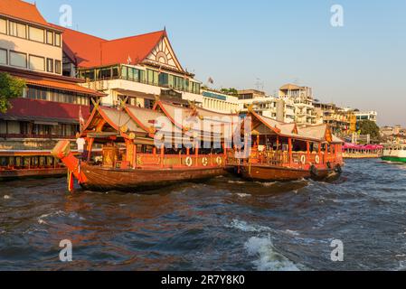 Schiffe am Pier für eine Flussfahrt auf einem Reiskahn auf dem Chao Phraya River in Bangkok. Traditioneller Reiskahn, erbaut für die Gastronomie am Fluss Stockfoto