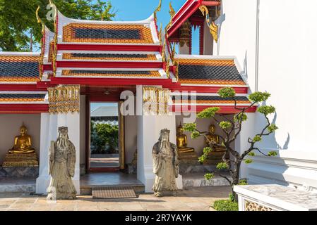 Chinesische Schutzfiguren neben einem Tor am Kreuzgang des Wat Pho Tempels in Bangkok Stockfoto