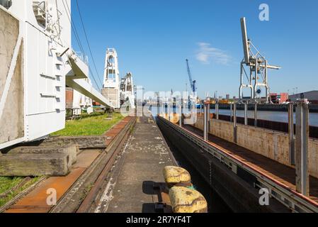 Portalkrane am Kai in einem Hafenbecken im Hamburger Bezirk kleiner Grasbrook. Hier befindet sich im Port Museum eine Ausstellung mit alten Hafenausrüstungen Stockfoto