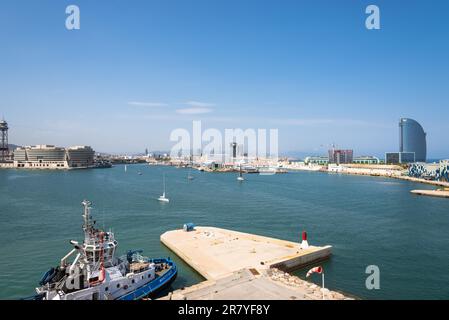 Blick auf das Hafenbecken Barcelona mit dem World Trade Center Barcelona und dem berühmten Yachthafen Port Vell. Im Vordergrund ist ein Schleppboot verankert. Ein Stockfoto