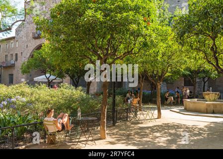 Die Studenten entspannten sich im Garten im Garten des ehemaligen Krankenhauses Santa Creu de Barcelona. Jetzt ist das wichtige gotische Ensemble das National Stockfoto