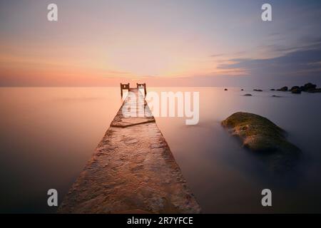 Sonnenuntergang über dem Horizont des Meeres. Leerer langer Pier am Strand auf der Insel Phu Quoc, Vietnam Stockfoto