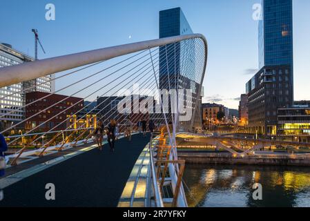 Einwohner, Touristen, Stadtbewohner, benutzen diese berühmte Hängebrücke, um den Fluss zu überqueren. Die Puente Zubizuri, Baskisch für weiße Brücke, auch genannt Stockfoto