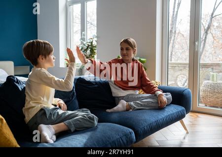 Ältere Schwester verbringt Zeit mit jüngerem Bruder zu Hause Stockfoto